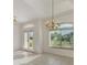 Living room featuring tiled floors, glass doors, chandelier and a large arched window at 5872 Mckinley Rd, Venice, FL 34293