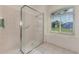 Glass enclosed shower in the bathroom features neutral tile, and a window for natural light at 5872 Mckinley Rd, Venice, FL 34293
