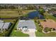 Aerial view of a home featuring a screened in pool, overlooking a tranquil pond and golf course at 6 Bunker Cir, Rotonda West, FL 33947