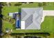 Aerial of property with screened pool, lush landscaping and neutral colored roof at 6 Bunker Cir, Rotonda West, FL 33947