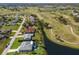 A golf course community aerial showcasing picturesque homes along the water and manicured golf greens at 6 Bunker Cir, Rotonda West, FL 33947