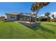 Sprawling back yard with outdoor seating, screened in pool, and lovely lawn at 6 Bunker Cir, Rotonda West, FL 33947