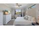 The serene bedroom features wood floors, a ceiling fan, and a calming view of the community pond at 6 Bunker Cir, Rotonda West, FL 33947