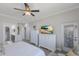 This bedroom offers neutral paint, white wood trim, a ceiling fan, and access to the ensuite bathroom at 6 Bunker Cir, Rotonda West, FL 33947