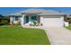 Attractive single-story home featuring a well-kept lawn, landscaping, and attached garage at 6 Bunker Cir, Rotonda West, FL 33947