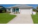 Picture of home with a well manicured lawn, lovely landscaping, and two-car garage at 6 Bunker Cir, Rotonda West, FL 33947