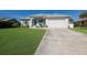 Inviting home exterior with well-maintained lawn, white garage door, and lovely curb appeal at 6 Bunker Cir, Rotonda West, FL 33947