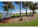 Scenic golf course view with the Rotonda Golf & Country Club sign and vibrant flowerbeds at 6 Bunker Cir, Rotonda West, FL 33947