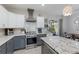 Chef's kitchen featuring a stainless steel range, custom vent hood, and island with granite countertop at 6 Bunker Cir, Rotonda West, FL 33947