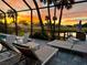 Relaxing poolside view at sunset with lounge chairs, palm trees, and a picturesque golf course backdrop at 6 Bunker Cir, Rotonda West, FL 33947