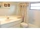 Bright bathroom features a single vanity, tub, and shower with patterned shower curtain at 6042 Red Maple Rd # 1001, Bradenton, FL 34210