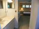 Bathroom leading to a bright bedroom with a king-size bed and large dresser at 6042 Red Maple Rd # 1001, Bradenton, FL 34210