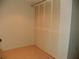 An empty bedroom with a light tile floor and large closet with louvered doors at 6042 Red Maple Rd # 1001, Bradenton, FL 34210