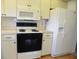 Well-maintained kitchen with a refrigerator, oven, microwave, and ample cabinet space at 6042 Red Maple Rd # 1001, Bradenton, FL 34210