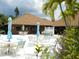 Community pool deck with umbrella tables and chairs surrounded by lush tropical landscaping at 6042 Red Maple Rd # 1001, Bradenton, FL 34210