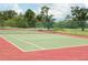 The tennis court is surrounded by a chain link fence and green trees at 6042 Red Maple Rd # 1001, Bradenton, FL 34210