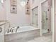 A luxurious bathroom featuring a soaking tub and walk-in glass shower at 6316 Walton Heath Pl, University Park, FL 34201