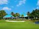 Beautiful clubhouse and golf course featuring blue tiled roofs, golf carts, a sand trap, and a tranquil pond at 6316 Walton Heath Pl, University Park, FL 34201
