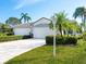 Charming home featuring a well-manicured lawn, mature palm trees, and a three-car garage at 6316 Walton Heath Pl, University Park, FL 34201