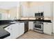 Kitchen with stainless steel appliances, white cabinets, and dark countertops at 6316 Walton Heath Pl, University Park, FL 34201