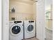 Bright laundry room featuring a Samsung washer and dryer and a wire rack shelf for storage at 6316 Walton Heath Pl, University Park, FL 34201