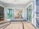 View of a spacious enclosed porch with wood-look tile flooring, ceiling fan, and view into the house at 6316 Walton Heath Pl, University Park, FL 34201