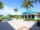 Community recreation center with lush landscaping, a patio, and lake views at 6316 Walton Heath Pl, University Park, FL 34201