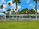 Beautiful tennis court with lush landscaping and well-maintained surface, perfect for recreational play at 6316 Walton Heath Pl, University Park, FL 34201