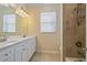 Bathroom featuring a double sink vanity, tiled shower, neutral paint, and window at 6857 Wild Lake Ter, Bradenton, FL 34212