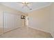 Well-lit bedroom with a ceiling fan, closet, tile floors, and a mounted television at 6857 Wild Lake Ter, Bradenton, FL 34212