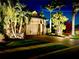 Elegant home featuring a two-car garage, brick driveway, and lush tropical landscaping illuminated at night at 6857 Wild Lake Ter, Bradenton, FL 34212