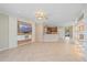 Open-concept living room with tile flooring, custom built-ins, and a view into the kitchen at 6857 Wild Lake Ter, Bradenton, FL 34212