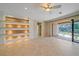 Open-concept living room with tile flooring, custom built-ins, and sliding doors to the lanai at 6857 Wild Lake Ter, Bradenton, FL 34212