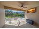 Enclosed patio with a ceiling fan, television, and stone flooring overlooks the pool and backyard at 6857 Wild Lake Ter, Bradenton, FL 34212