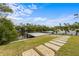 Beautiful backyard with a modern dock, green lawn, and stone pathway leading to the waterfront at 7003 Holmes Blvd, Holmes Beach, FL 34217