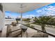 This balcony features neutral outdoor seating, a ceiling fan, and a sunny view of the street at 7003 Holmes Blvd, Holmes Beach, FL 34217