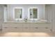 Modern bathroom featuring double vanity, sleek white cabinets, and illuminated mirrors at 7003 Holmes Blvd, Holmes Beach, FL 34217