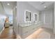 Bathroom featuring double vanity, illuminated mirrors and tile flooring near the bedroom at 7003 Holmes Blvd, Holmes Beach, FL 34217