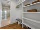 Walk-in closet with built-in shelving and a view into a bright bathroom with a glass shower at 7003 Holmes Blvd, Holmes Beach, FL 34217