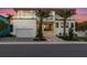 Stunning modern home with a clean white facade, balcony, and lush tropical landscaping at sunset at 7003 Holmes Blvd, Holmes Beach, FL 34217
