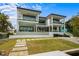 Beautiful modern two-story home with multiple balconies and lush landscaping at 7003 Holmes Blvd, Holmes Beach, FL 34217