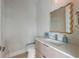A stylish half bath with a textured wall, a decorative mirror, and sleek fixtures at 7003 Holmes Blvd, Holmes Beach, FL 34217