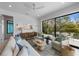 Bright living room with stylish furniture, ceiling fan, and a sliding glass door to the outdoor patio at 7003 Holmes Blvd, Holmes Beach, FL 34217