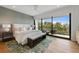 Calm main bedroom with hardwood floors, a seating bench, and a large window overlooking trees at 7003 Holmes Blvd, Holmes Beach, FL 34217