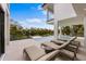 Outdoor lounge chairs near a pool and spa with waterfront views in a tropical backyard at 7003 Holmes Blvd, Holmes Beach, FL 34217