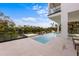 Modern pool and spa with waterfront views and outdoor seating in a tropical backyard at 7003 Holmes Blvd, Holmes Beach, FL 34217
