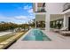 Modern pool and spa with waterfront views and outdoor seating in a tropical backyard at 7003 Holmes Blvd, Holmes Beach, FL 34217