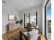 Bright sitting room with hardwood floors, stylish furniture, TV, and sliding glass doors to outdoor terrace at 7003 Holmes Blvd, Holmes Beach, FL 34217