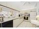 A well lit kitchen with white cabinets, updated appliances, and a view of the dining area at 7407 29Th Avenue W Dr # 2288, Bradenton, FL 34209