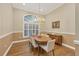 Formal dining room with hardwood floors, chandelier lighting, and a large window with shutter shades at 7665 Portstewart Dr, Lakewood Ranch, FL 34202